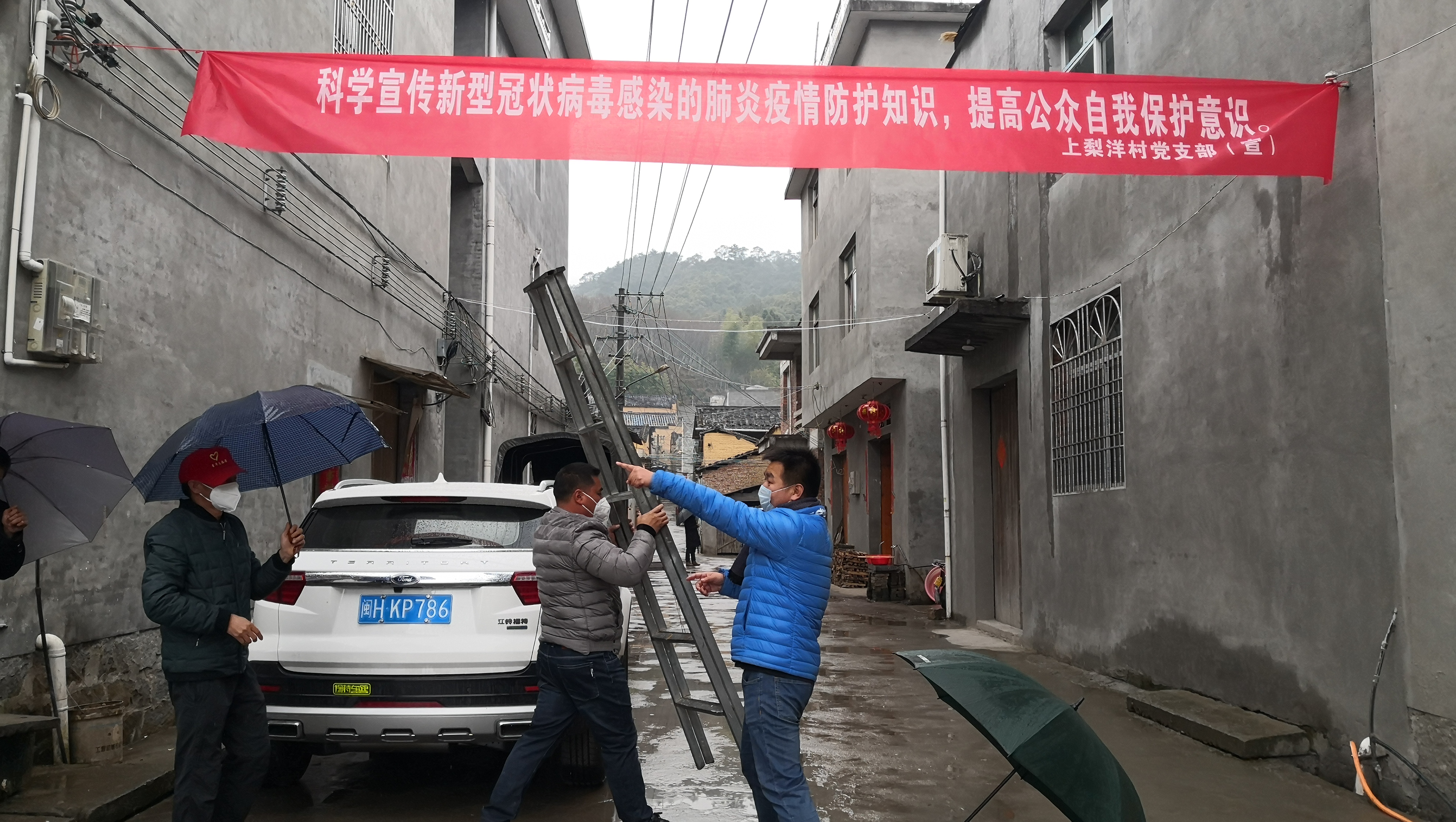1.屏南县上梨洋村第一书记柳斌（右一）组织村两委悬挂防疫宣传标语横幅.jpg